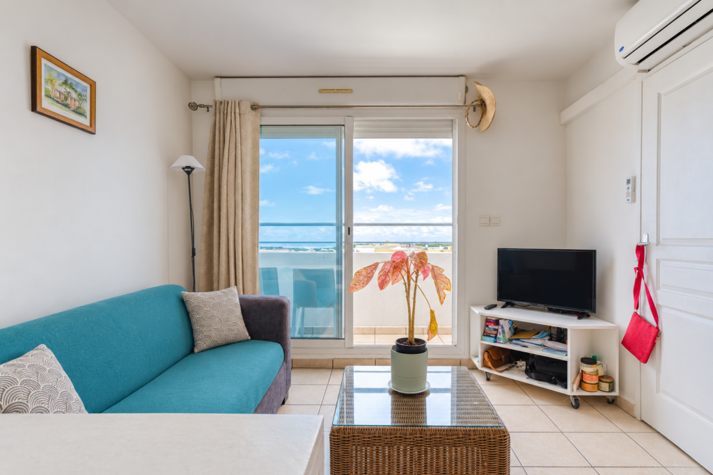 Séjour du studio avec baie vitrée et vue mer, Saint-Denis Butor